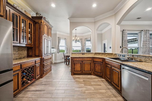 872 Hidden Pass, Royse City, TX 75189 - kitchen with appliances with stainless steel finishes, light wood finished floors, decorative backsplash, glass insert cabinets, and a chandelier