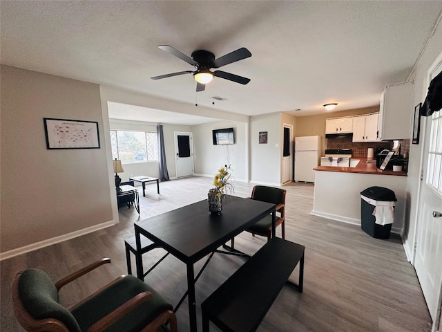 3007 Gaines St, Bossier City, LA 71111 - dining area with light wood-style floors, a ceiling fan, baseboards, and a textured ceiling