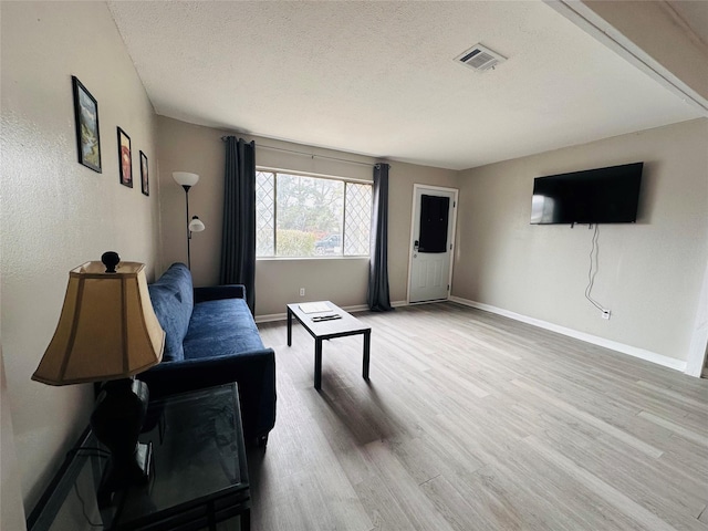 3007 Gaines St, Bossier City, LA 71111 - living room with light wood finished floors, a textured ceiling, and baseboards