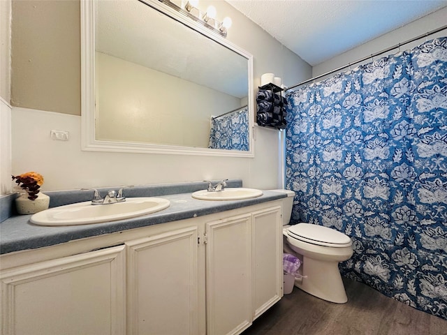 3007 Gaines St, Bossier City, LA 71111 - bathroom featuring wood finished floors, double vanity, toilet, and a shower with curtain