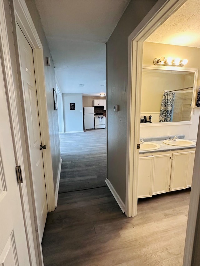 3007 Gaines St, Bossier City, LA 71111 - corridor with a sink, wood finished floors, and baseboards