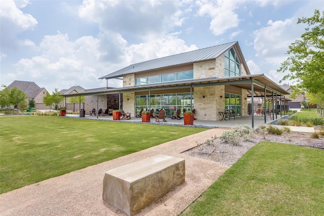 16324 Toledo Bend Ct, Prosper, TX 75078 - back of house with stone siding, a patio, a lawn, and metal roof