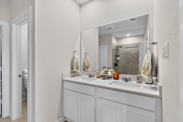 403 Pendant Dr, Royse City, TX 75189 - bathroom with a shower stall, double vanity, tile patterned flooring, toilet, and a textured wall