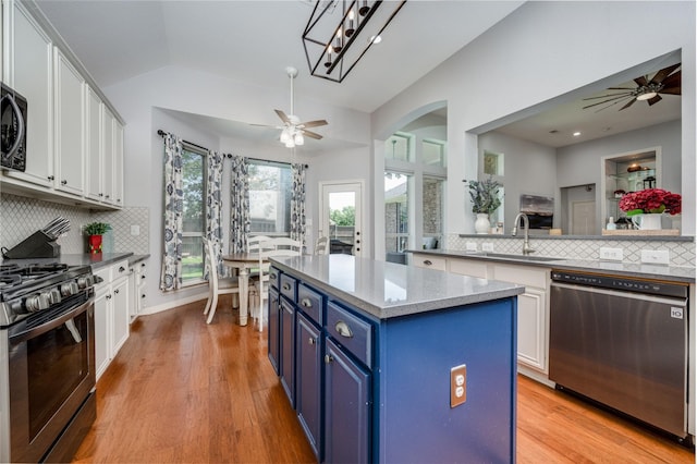 1200 Stonehedge Pl, Flower Mound, TX 75028 - kitchen featuring stainless steel appliances, blue cabinets, ceiling fan, white cabinets, and vaulted ceiling