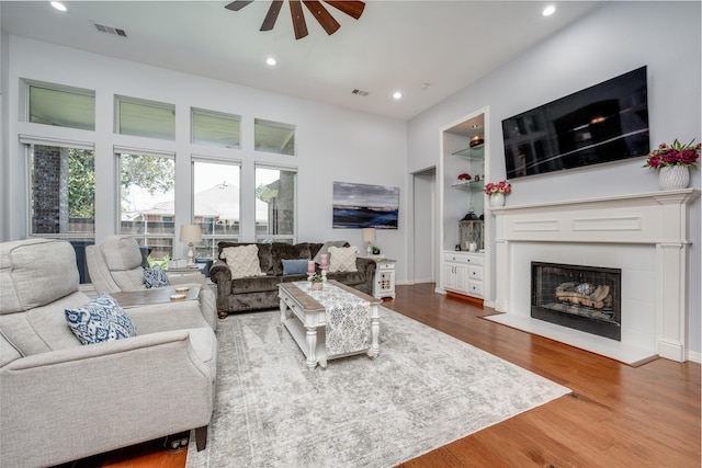 1200 Stonehedge Pl, Flower Mound, TX 75028 - living room with ceiling fan, recessed lighting, built in shelves, wood finished floors, and a tile fireplace