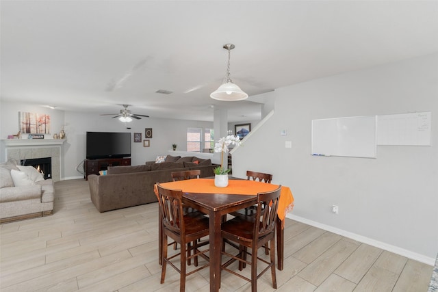 303 Highland Glen Dr, Wylie, TX 75098 - dining room with light wood-style floors, a ceiling fan, a fireplace, and baseboards