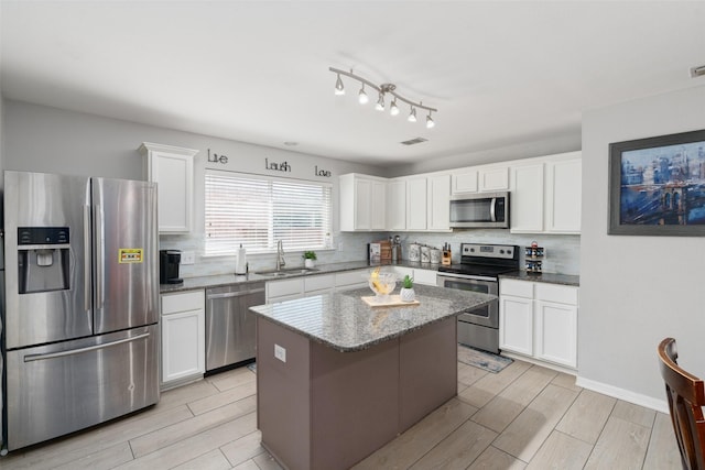 303 Highland Glen Dr, Wylie, TX 75098 - kitchen with stainless steel appliances, a sink, wood tiled floors, and decorative backsplash