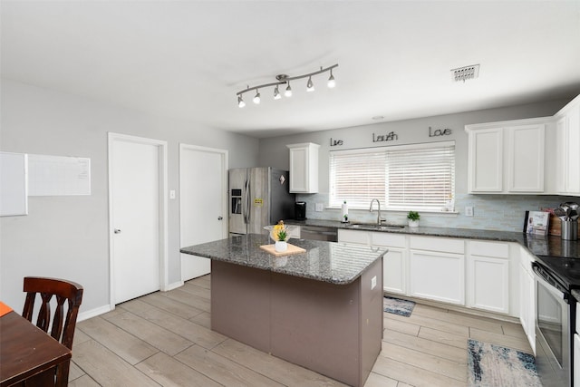 303 Highland Glen Dr, Wylie, TX 75098 - kitchen with appliances with stainless steel finishes, a sink, wood tiled floors, a center island, and decorative backsplash