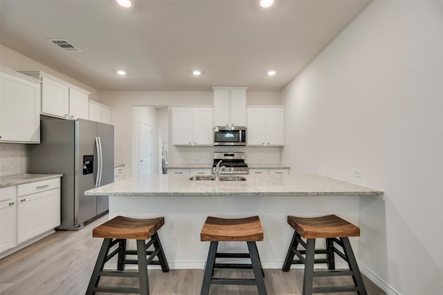 2705 Hancock Ln, Celina, TX 75009 - kitchen with stainless steel appliances, tasteful backsplash, white cabinets, a breakfast bar, and recessed lighting