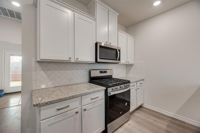 2705 Hancock Ln, Celina, TX 75009 - kitchen with appliances with stainless steel finishes, light wood-style flooring, backsplash, white cabinets, and recessed lighting