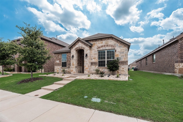 2705 Hancock Ln, Celina, TX 75009 - french country inspired facade with stone siding, a front yard, and cooling unit