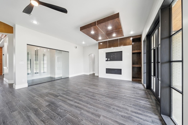 2522 Hardwick Ln, Cedar Hill, TX 75104 - unfurnished living room with dark wood-style flooring, a ceiling fan, arched walkways, baseboards, and a fireplace