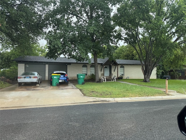 917 Susan St, Robinson, TX 76706 - view of front of house featuring brick siding, a front lawn, concrete driveway, and an attached garage