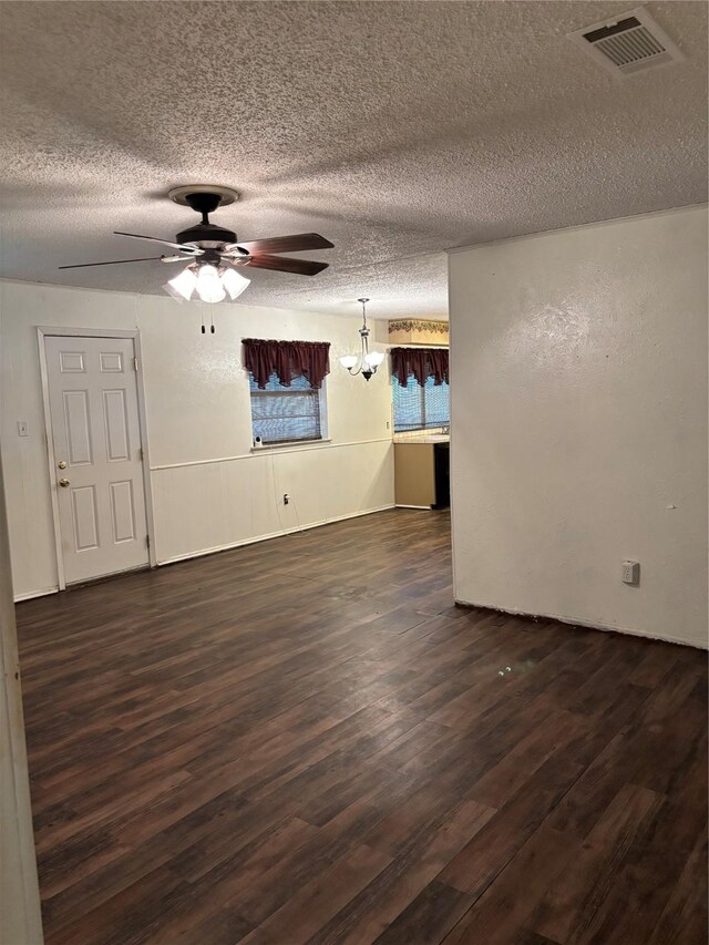 621 Lynnewood Ave, Burleson, TX 76028 - unfurnished room with dark wood-style floors, a textured ceiling, a ceiling fan, and a chandelier