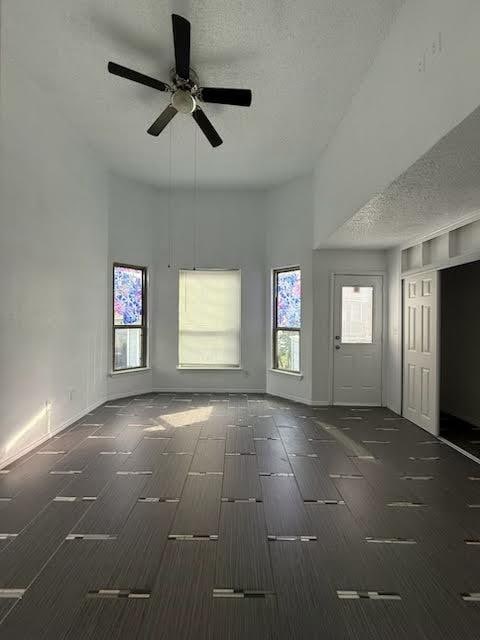 3404 W Country Club Dr Unit 264, Irving, TX 75038 - empty room with ceiling fan, a textured ceiling, and a high ceiling