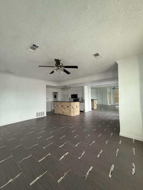 3404 W Country Club Dr Unit 264, Irving, TX 75038 - unfurnished living room with a ceiling fan, a textured ceiling, and dark colored carpet