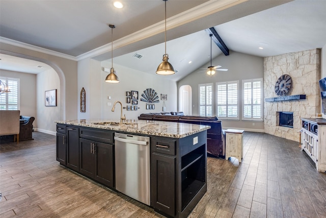 3900 Silent Water St, Mckinney, TX 75071 - kitchen with stainless steel dishwasher, arched walkways, open floor plan, a sink, and a center island with sink