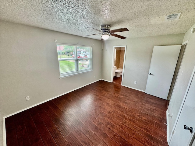 517 Gristmill Ln, Everman, TX 76140 - unfurnished bedroom featuring a textured ceiling, wood finished floors, baseboards, ensuite bathroom, and a ceiling fan