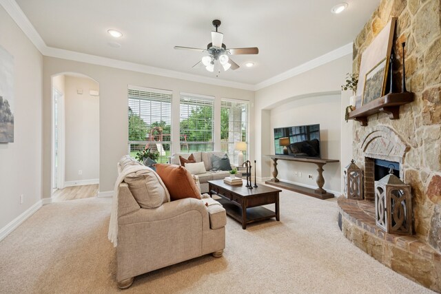 5809 Sterling Trl, Mckinney, TX 75071 - living area with carpet, a ceiling fan, arched walkways, a stone fireplace, and crown molding