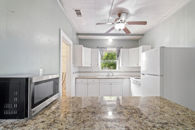 408 W Trinity St, Groesbeck, TX 76642 - kitchen with freestanding refrigerator, light stone countertops, dishwashing machine, white cabinetry, and ceiling fan
