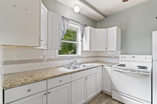 408 W Trinity St, Groesbeck, TX 76642 - kitchen with electric range, light wood-style flooring, backsplash, white cabinets, and light stone countertops