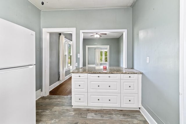 408 W Trinity St, Groesbeck, TX 76642 - kitchen with freestanding refrigerator, white cabinetry, dark wood-type flooring, ceiling fan, and stone countertops