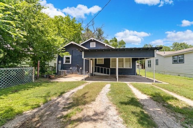 408 W Trinity St, Groesbeck, TX 76642 - rear view of house featuring driveway, a lawn, and a carport