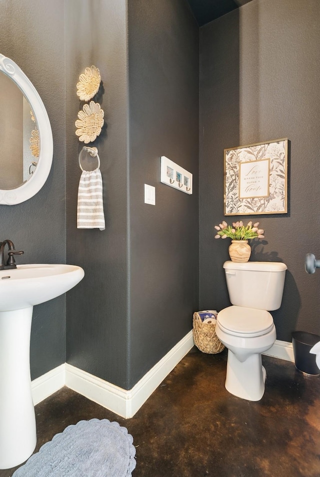 2011 Twin Creeks Cir, Pilot Point, TX 76258 - bathroom featuring unfinished concrete flooring, toilet, baseboards, and a sink