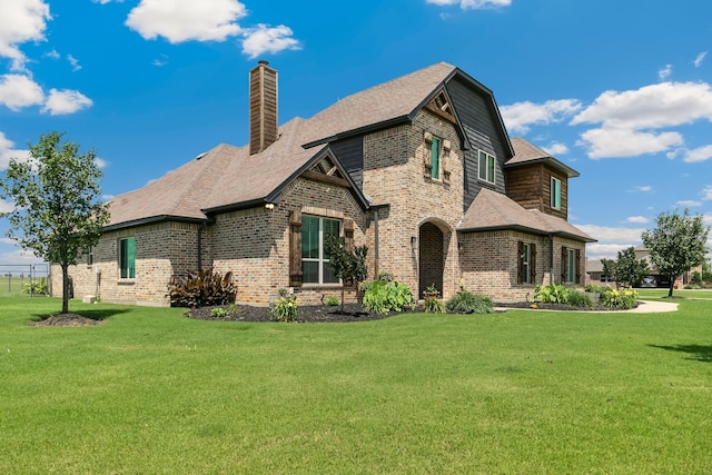 2011 Twin Creeks Cir, Pilot Point, TX 76258 - view of home's exterior featuring brick siding, a lawn, and a chimney