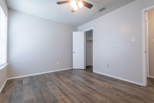 6104 Brookfall Dr, Arlington, TX 76018 - unfurnished bedroom with dark wood-type flooring, baseboards, a closet, a ceiling fan, and a textured ceiling