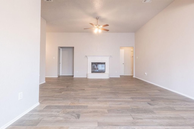 6104 Brookfall Dr, Arlington, TX 76018 - unfurnished living room with a ceiling fan, wood finished floors, a brick fireplace, and baseboards