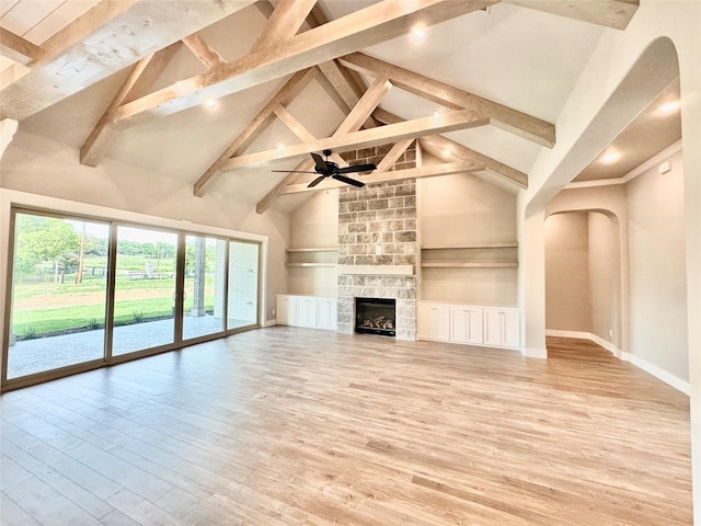 9604 Hester Ln, Argyle, TX 76226 - unfurnished living room with high vaulted ceiling, arched walkways, beam ceiling, light wood-style floors, and baseboards