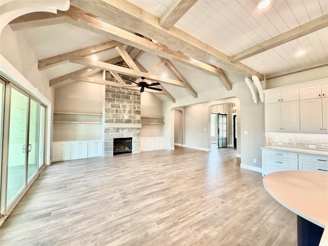 9604 Hester Ln, Argyle, TX 76226 - unfurnished living room with arched walkways, a ceiling fan, plenty of natural light, beamed ceiling, and light wood-style floors