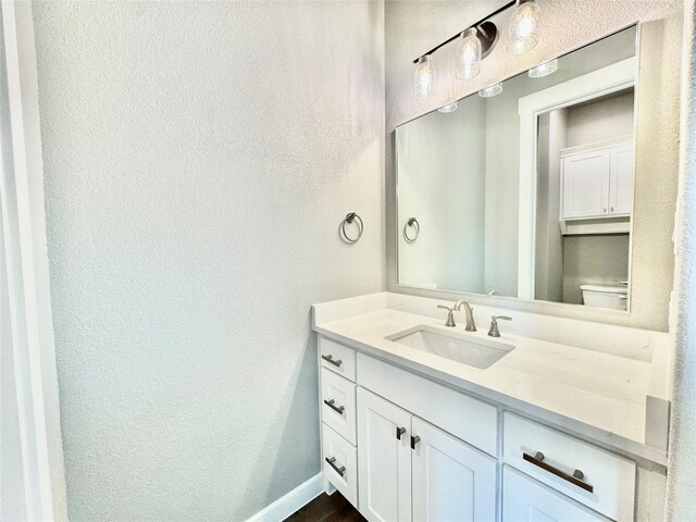 9604 Hester Ln, Argyle, TX 76226 - bathroom featuring a textured wall, vanity, toilet, baseboards, and wood finished floors