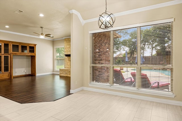 3600 Big Timber Ln, Granbury, TX 76049 - unfurnished dining area with ornamental molding, a fireplace, a ceiling fan, baseboards, and a chandelier