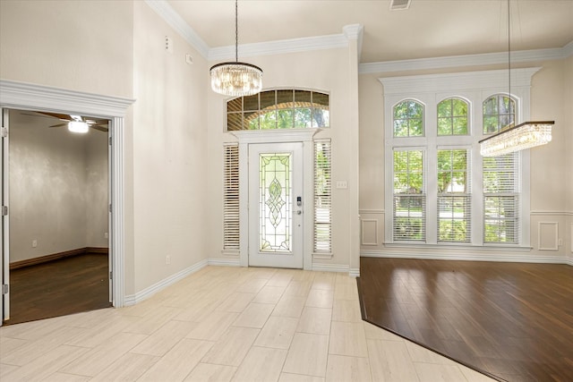 3600 Big Timber Ln, Granbury, TX 76049 - entrance foyer featuring crown molding, ceiling fan, light wood-style floors, a chandelier, and wainscoting