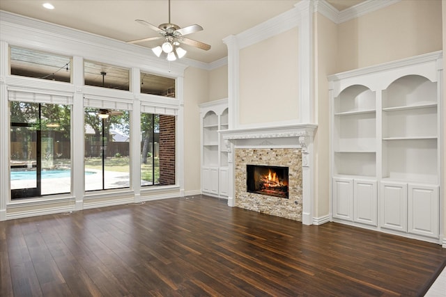 3600 Big Timber Ln, Granbury, TX 76049 - unfurnished living room with ceiling fan, dark wood-type flooring, a lit fireplace, ornamental molding, and built in features