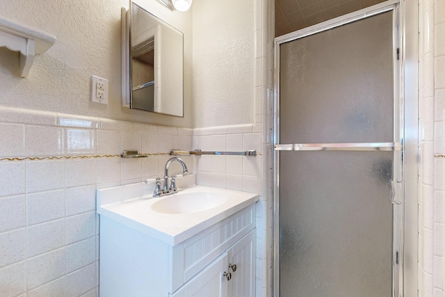 204 Cacti Dr, Lakeside, TX 76108 - full bathroom featuring vanity, a stall shower, wainscoting, a textured wall, and tile walls