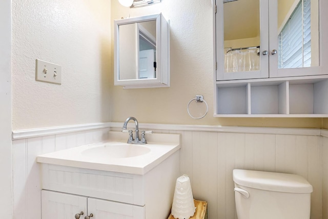 204 Cacti Dr, Lakeside, TX 76108 - bathroom featuring a wainscoted wall, vanity, toilet, and a decorative wall