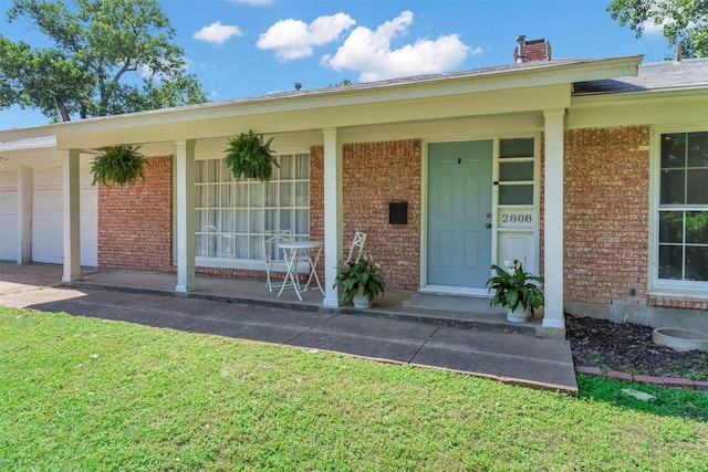 2808 Wren Ave, Fort Worth, TX 76133 - view of exterior entry with covered porch, brick siding, a chimney, a garage, and a lawn