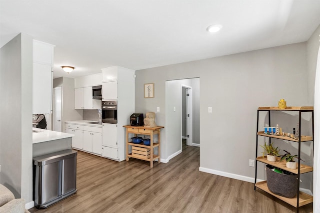 2808 Wren Ave, Fort Worth, TX 76133 - kitchen with appliances with stainless steel finishes, light wood finished floors, light countertops, white cabinets, and baseboards