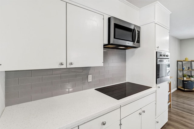 2808 Wren Ave, Fort Worth, TX 76133 - kitchen featuring stainless steel appliances, white cabinets, decorative backsplash, wood finished floors, and light stone counters
