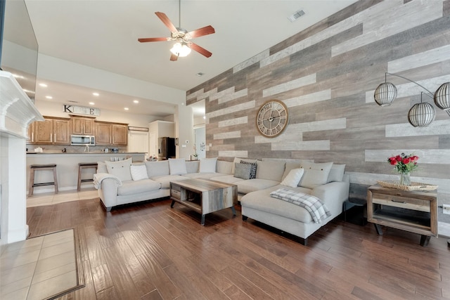 3113 Summer Dr, Little Elm, TX 75068 - living room with wooden walls, a ceiling fan, wood finished floors, an accent wall, and recessed lighting