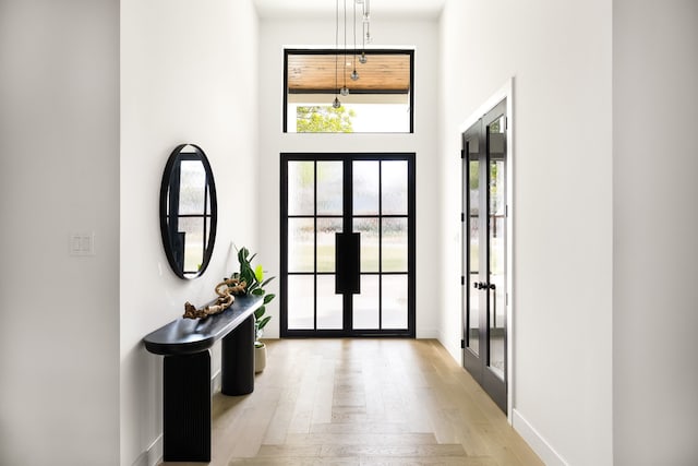 13845 Peyton Dr, Dallas, TX 75240 - entrance foyer with french doors, light wood-style flooring, baseboards, and a high ceiling