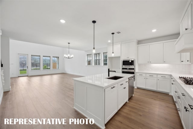 4180 Kestrel St, Prosper, TX 75078 - kitchen featuring a sink, stainless steel appliances, backsplash, a chandelier, and light wood-type flooring