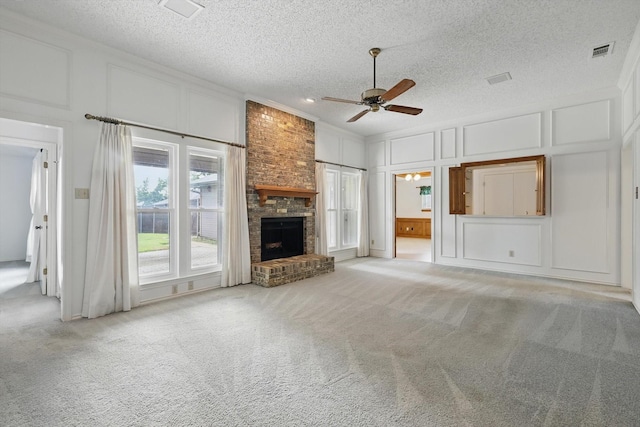 220 Simmons Dr, Coppell, TX 75019 - unfurnished living room with a decorative wall, ceiling fan, carpet, a fireplace, and a textured ceiling