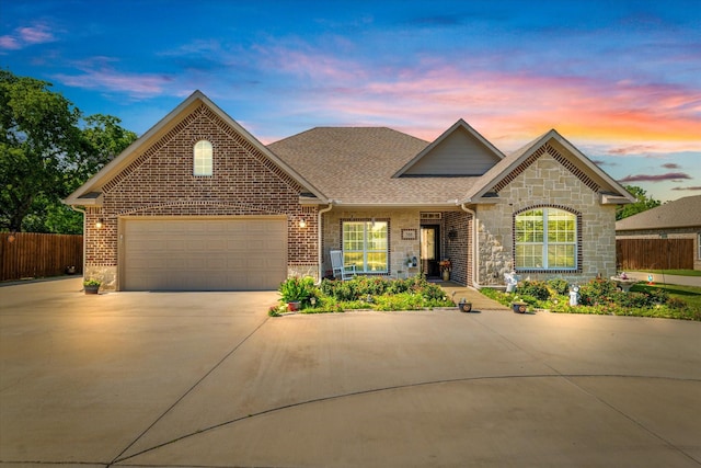 768 Northside Dr, Pilot Point, TX 76258 - view of front of property featuring concrete driveway, a garage, stone siding, roof with shingles, and brick siding