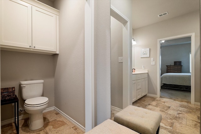 768 Northside Dr, Pilot Point, TX 76258 - ensuite bathroom featuring stone tile flooring, toilet, vanity, and baseboards