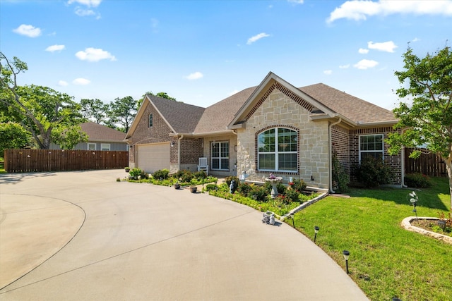 768 Northside Dr, Pilot Point, TX 76258 - view of front of home with driveway, stone siding, a garage, brick siding, and roof with shingles