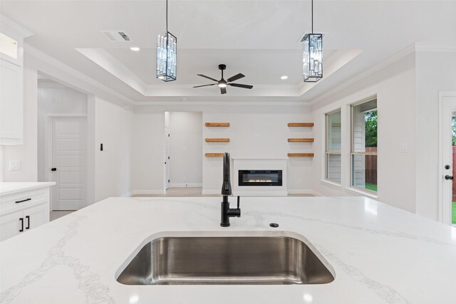 5627 Barkridge Dr, Granbury, TX 76048 - kitchen featuring a sink, hanging light fixtures, a tray ceiling, light stone countertops, and ornamental molding